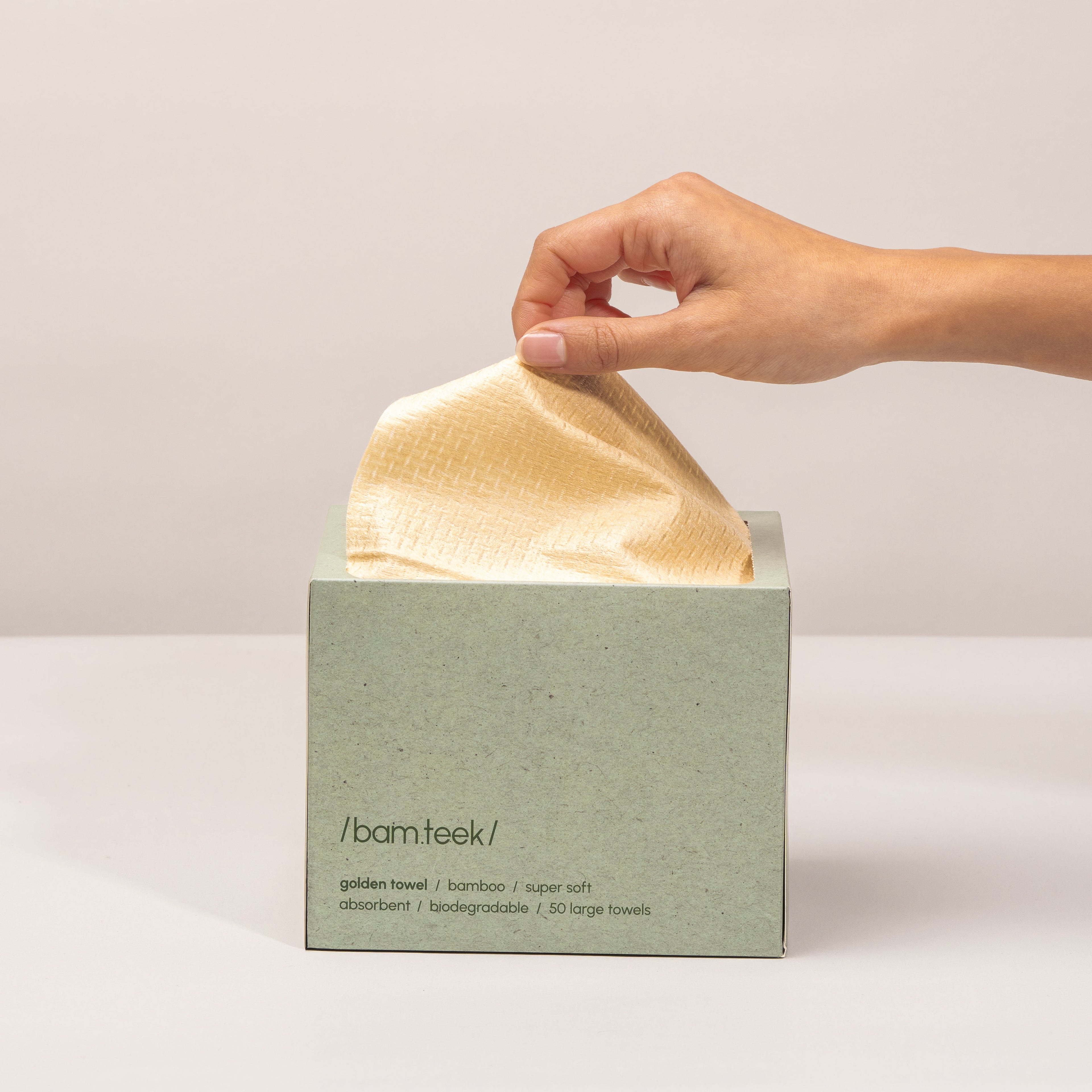 Person holding a towel from the Bamteek Discovery Pack box of single-use towels. Person holding a towel from the Bamteek Discovery Pack box of single-use towels.