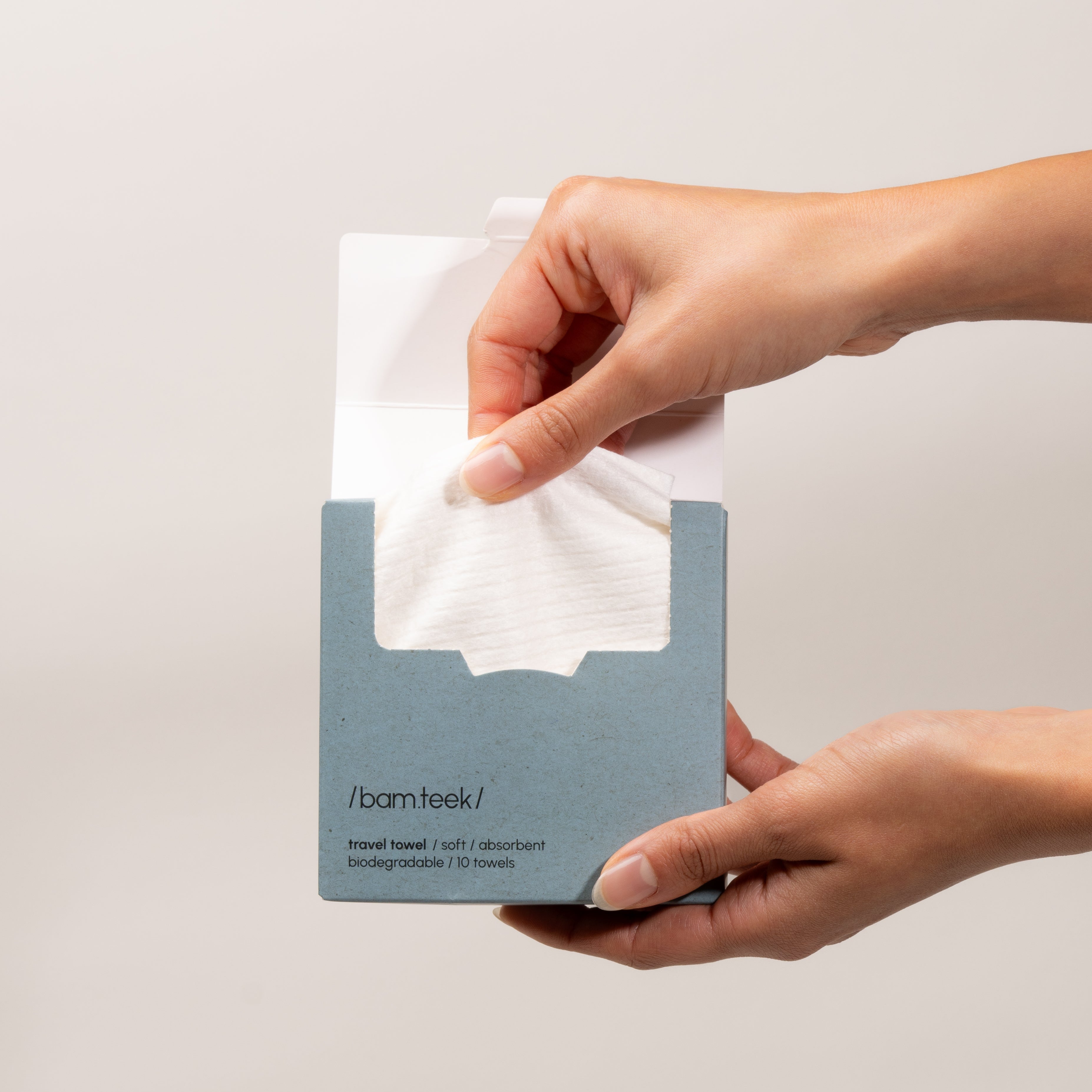 Kuwaiti Hand holding a pack of Travel Bundle towels by Bamteek, showcasing the single-use skincare towels for clean travel.